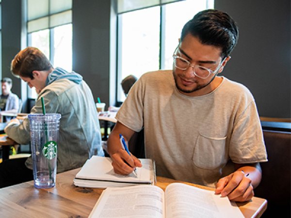 Student studying at a table at the campus Starbucks