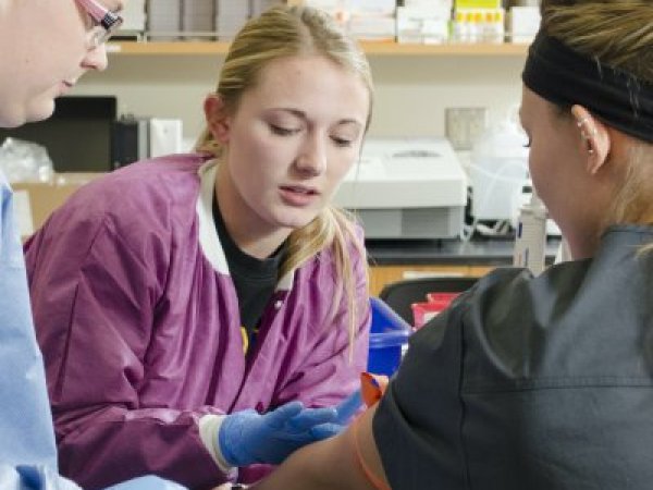 Student drawing blood in lab