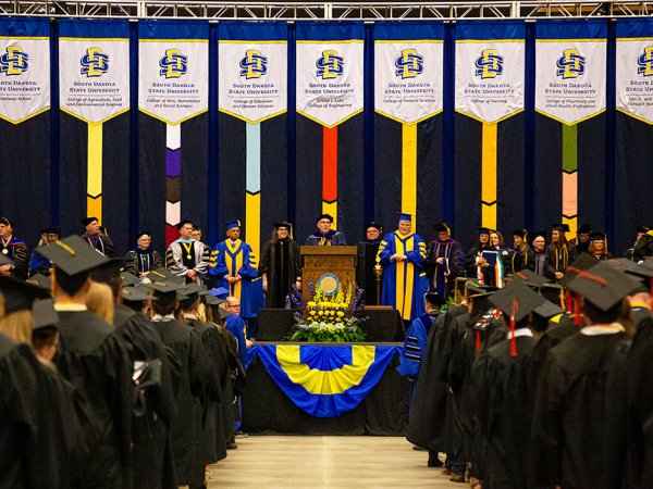 One of the 2023 South Dakota State University commencement ceremonies at the Dacotah Bank Center in Brookings is show, with SDSU President Barry Dunn addressing graduates.