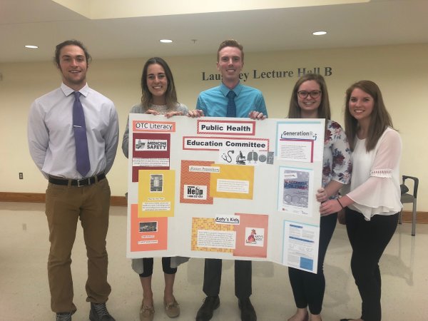 Students with a public health education poster