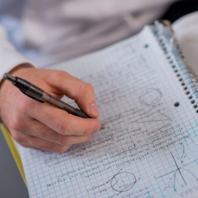 close up of hand writing in notebook