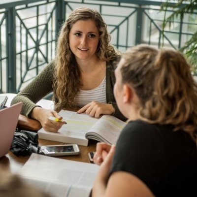 Two students studying from textbooks