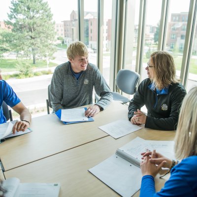 Students sitting at a table talking.