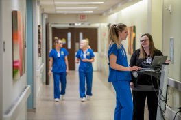 Nurses standing in a hallway.