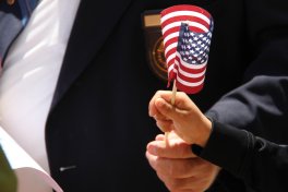 View of a veteran and child holding a small flag.