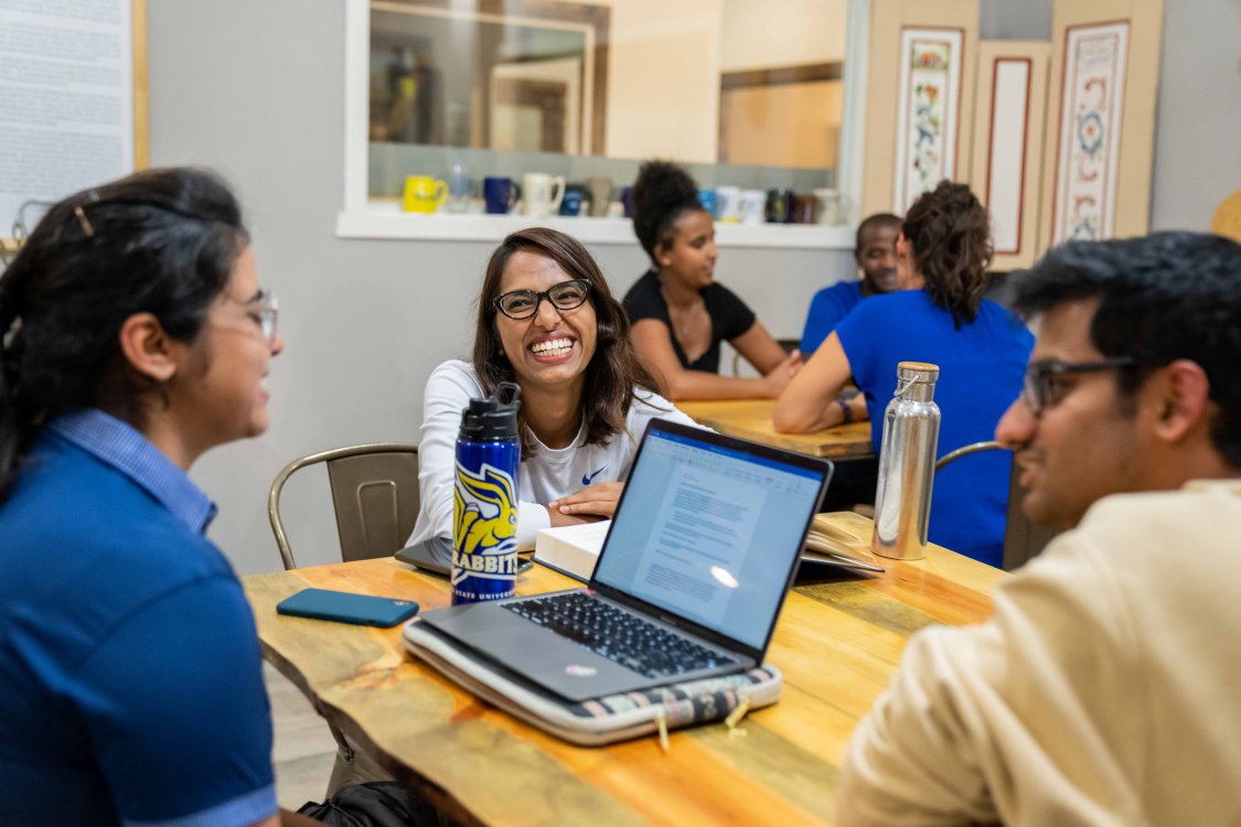 Three students sitting at a table studying together.