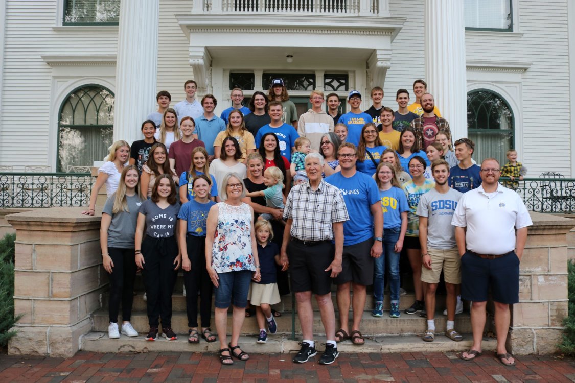 Honors students pose with the Fishback family outside their home