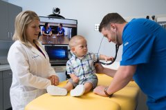 Professor working with student examing a patient.