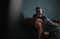 public domain photo of man sitting on couch with face in palm of his hand