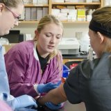 Student drawing blood in lab