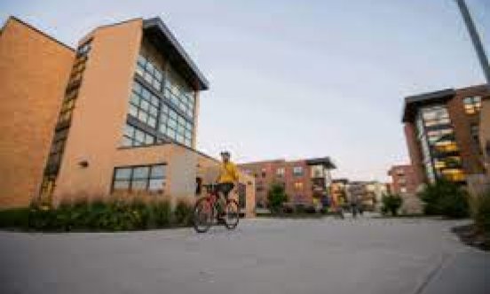 Student riding a bike through Jackrabbit Village