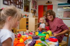 student teacher playing with children in classroom