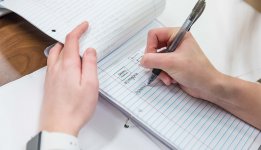 close up image of hands and a notebook 