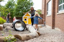 Student teacher and child playing on log