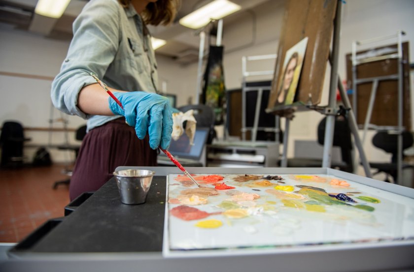 Student painting in a studio.