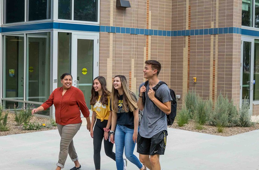 Students walking with. faculty member outside of AISC