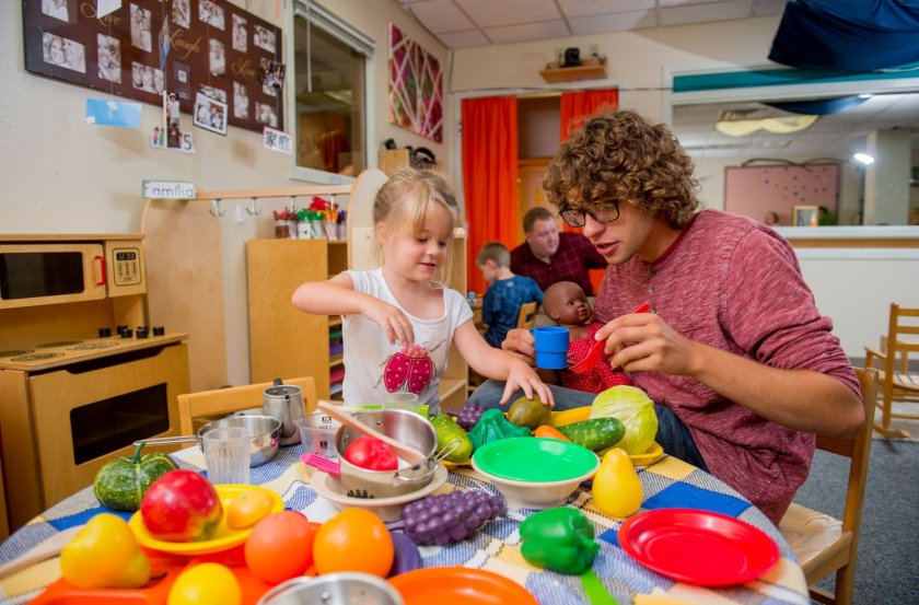 Teacher and student playing with colorful toys