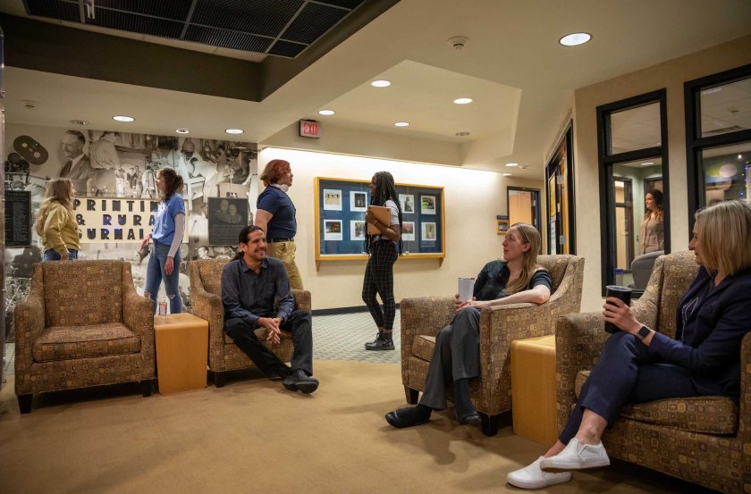 A group of people sitting in chairs talking