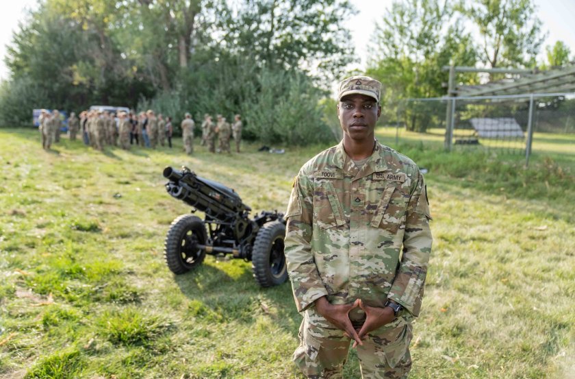 ROTC cadet standing in front of a cannon.